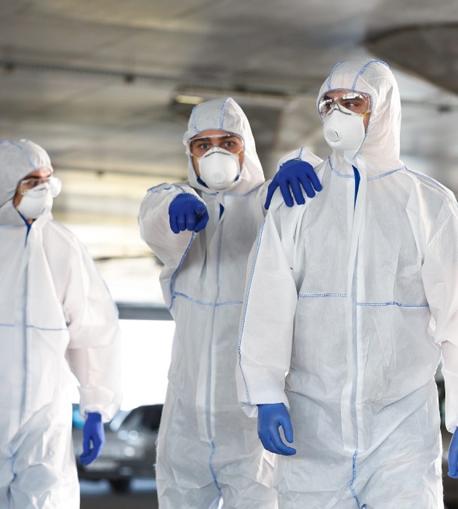 Frightened Man in virus protective suit showing with finger on something, coronavirus pandemic, biohazard, covid 19